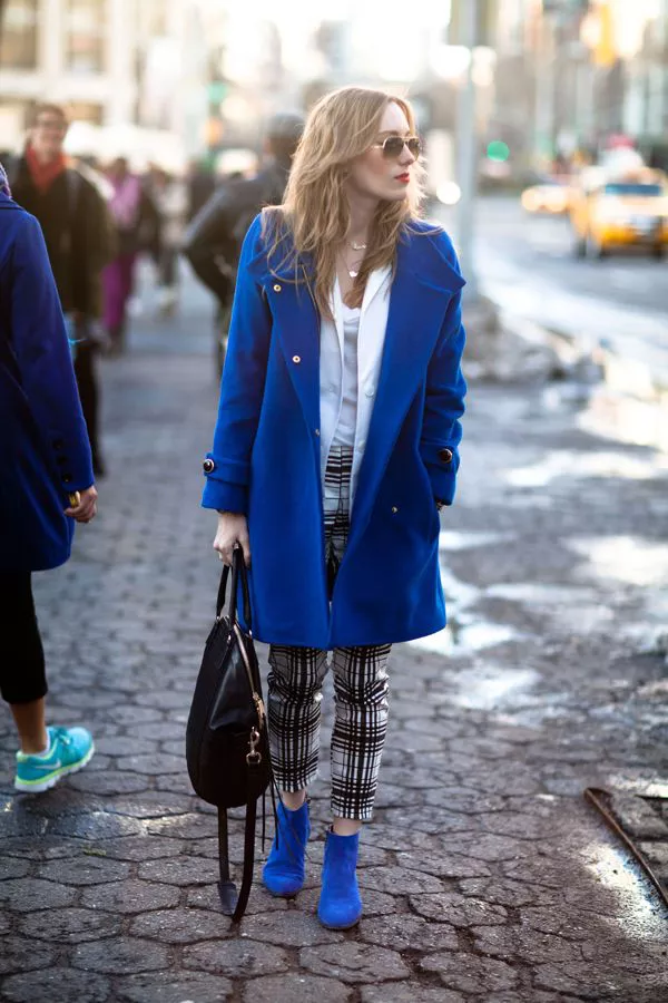 Девушка в брюках в клетку и синем пальто