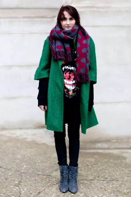 Девушка в черных джеггинсах, кофте, зеленом пальто и серых ботильонах