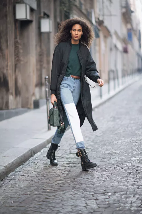 Девушка в двуцветных джинсах, армейских ботинках и черном плаще