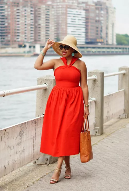 Девушка в оранжевом платье миди, соломенная шляпа и босоножки