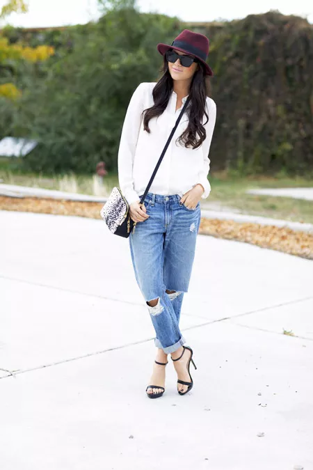 Девушка в рваных джинсах, рубашка, черные босоножки и шляпа