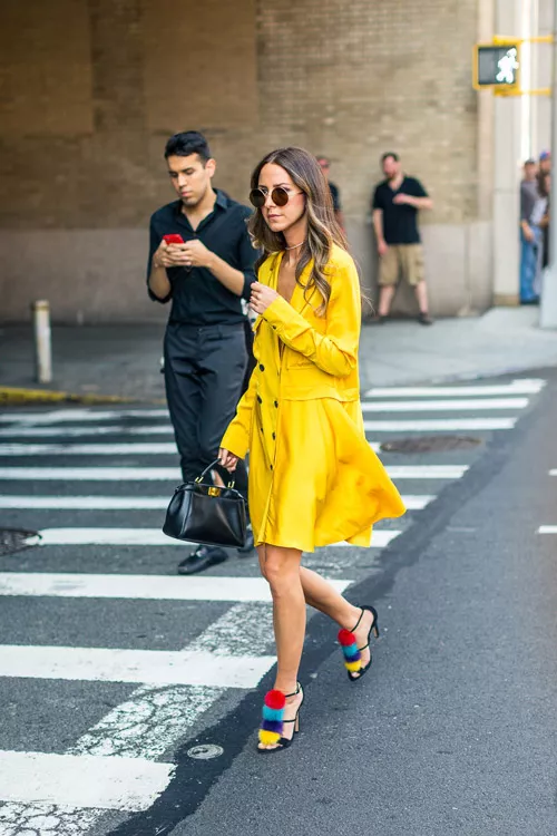 Девушка в желтом платье и красивых босоножках с разноцветными помпонами - уличная мода Нью-Йорка весна/лето 2017