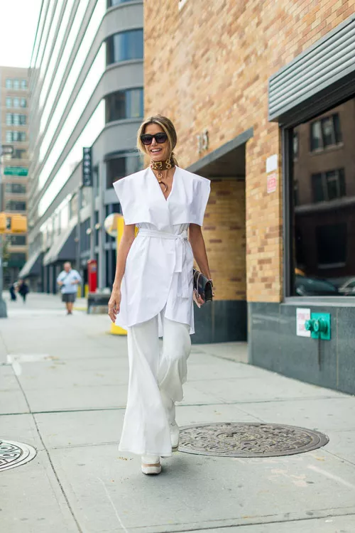 Модель в белых брюках и блузке - уличная мода Нью-Йорка весна/лето 2017