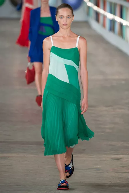 Модель в зеленом платье с плиссированной юбкой от boss hugo boss