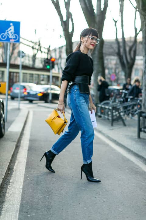 Девушка в синих джинсах и черном джемпере