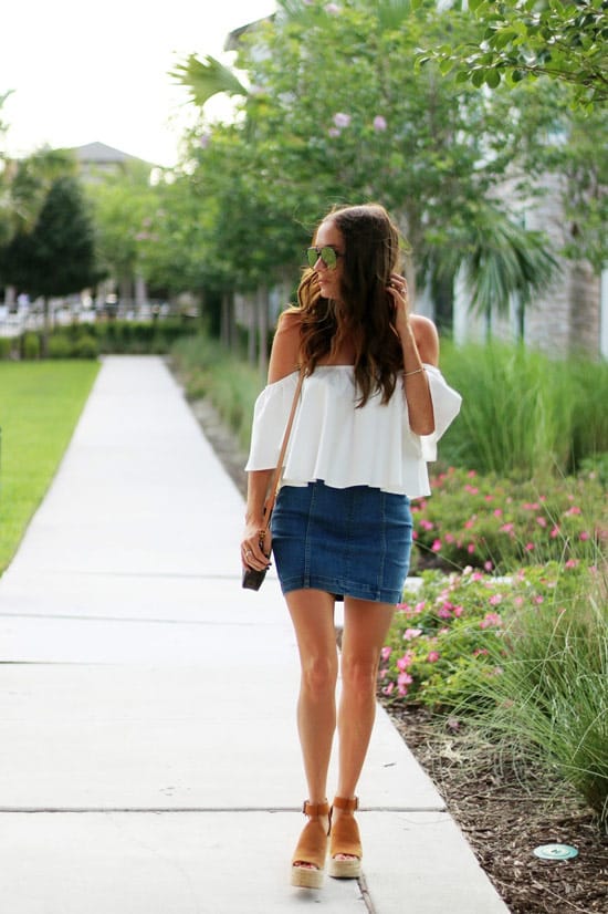 Девушка в джинсовой мини юбке и белая блузка с открытыми плечами