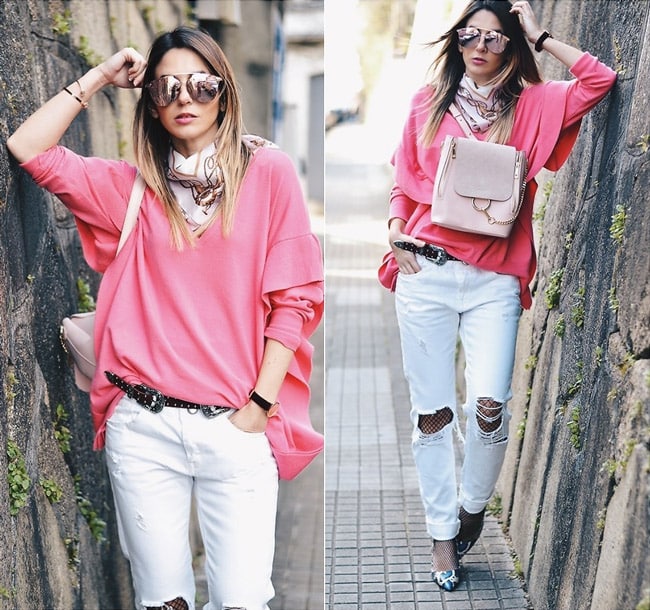 Девушка в белых рваных джинсах, колготки в сетку и розовый джемпер
