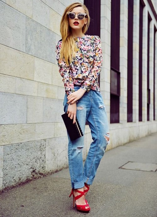 Девушка в джинсах бойфрендах, блузка с цветочным принтом и красные босоножки