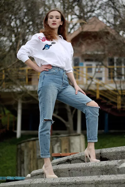 Девушка в рваных джинсах и белой рубашке