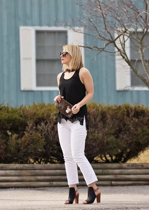 Девушка в белых укороченных джинсах и черная майка