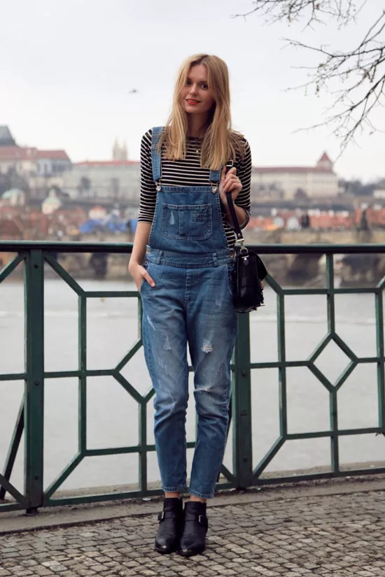 Девушка в джинсовом комбинезоне и полосатая водолазка