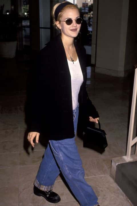Дрю Бэрримор в синих джинсах с большими карманами и черной куртке