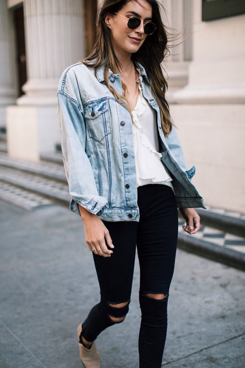 Блогер в черных рваных джинсах, белом топе и джинсовке 