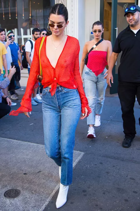 Кендалл Дженнер в красной блузке и джинсах