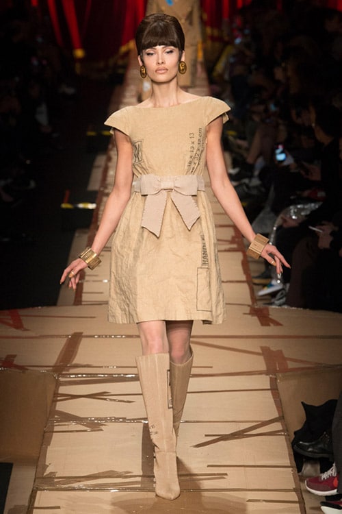 Модель в бежевом платье с бантом на талии от Moschino