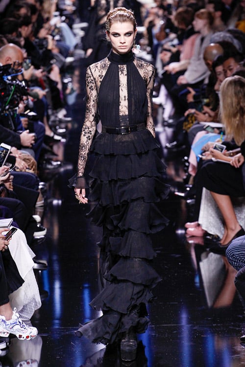 Модель в черном платье макси с многослойной юбкой и гипюром от Elie Saab
