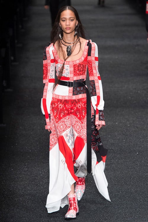 Модель в красно-белом платье макси с кожаным ремнем от Alexander McQueen