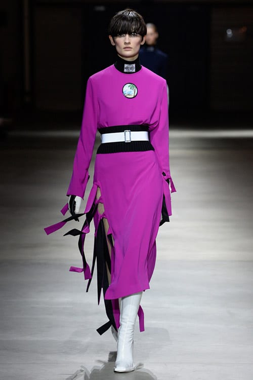 Модель в трикотажном платье цвета фуксии с поясом от Kenzo