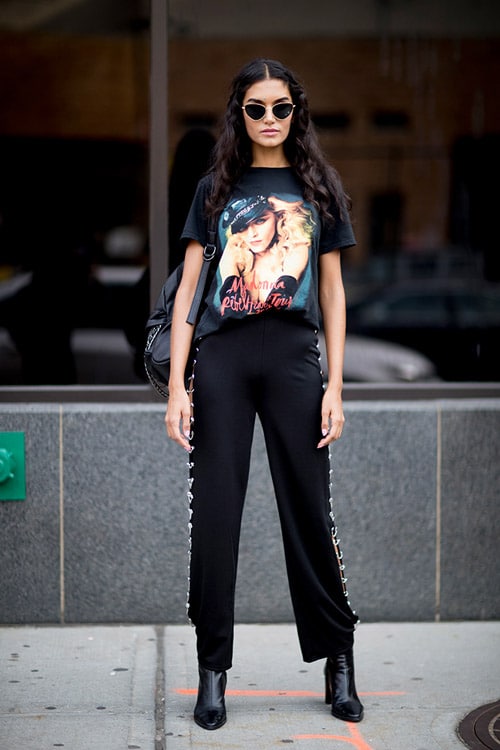 Девушка в черных брюках, ботильонах и футболке с принтом