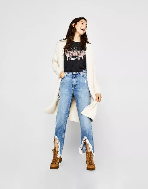 Модель bershka в рваных джинсах, футболке и кардигане