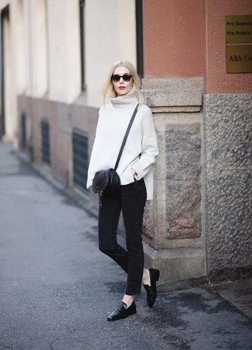 Девушка в белом свитере и черных джинсах