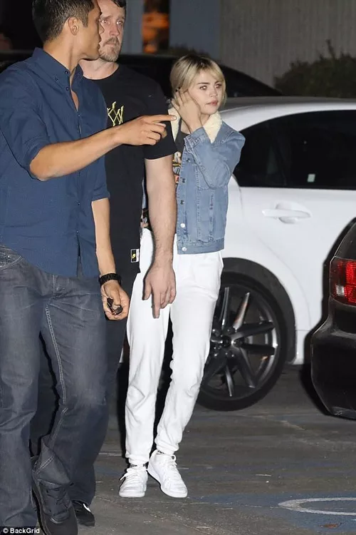 Селена Гомес в джинсовой куртке и белых спортивных брюках