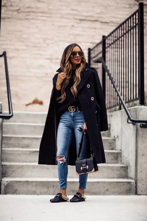 Девушка в рваных джинсах, черная кофта, пальто с пуговицами, сумочка