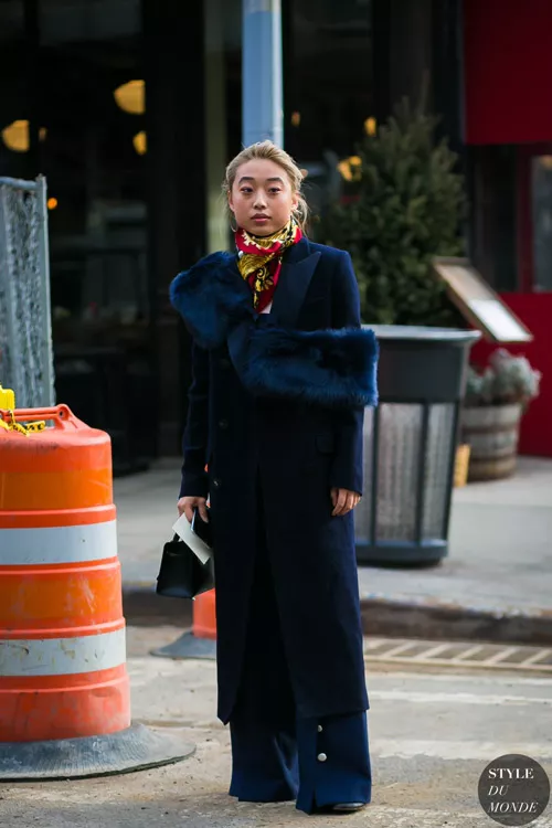 Девушка в длинном синем пальто с меховым воротником, широкие брюки клеш и яркий платок