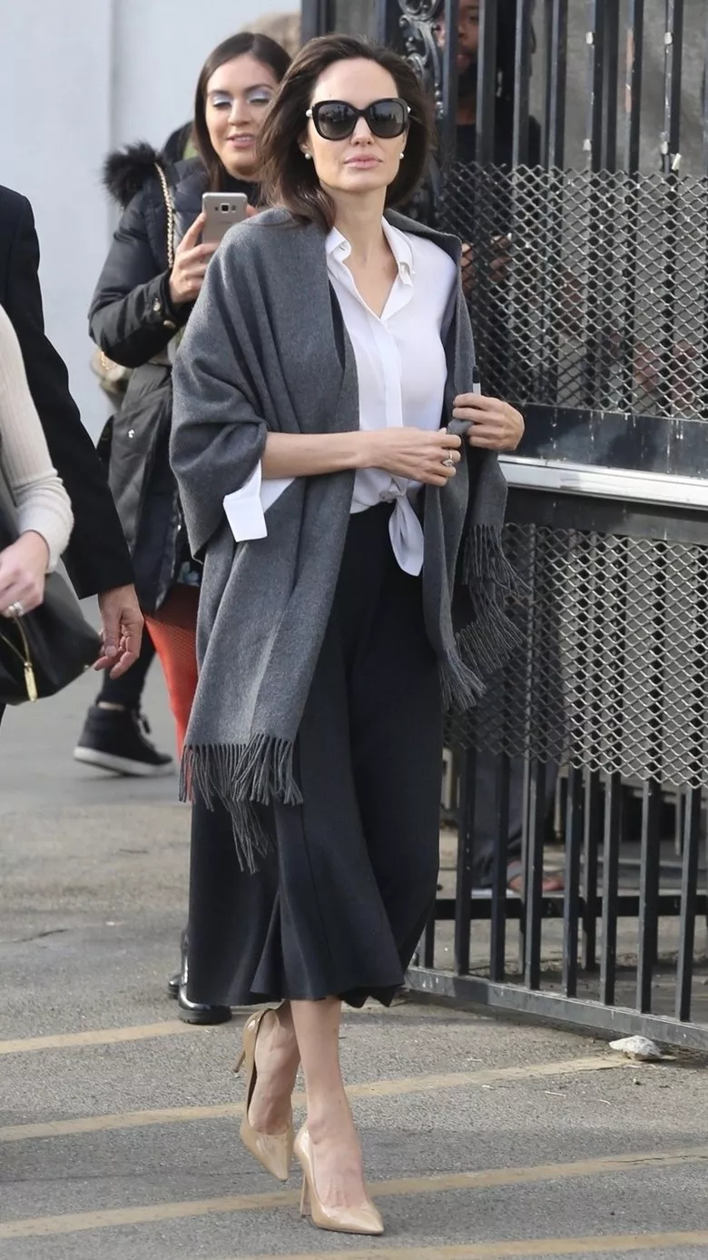 Анджелина Джоли в сером палантине, белой рубашке с узлом и черной юбке миди
