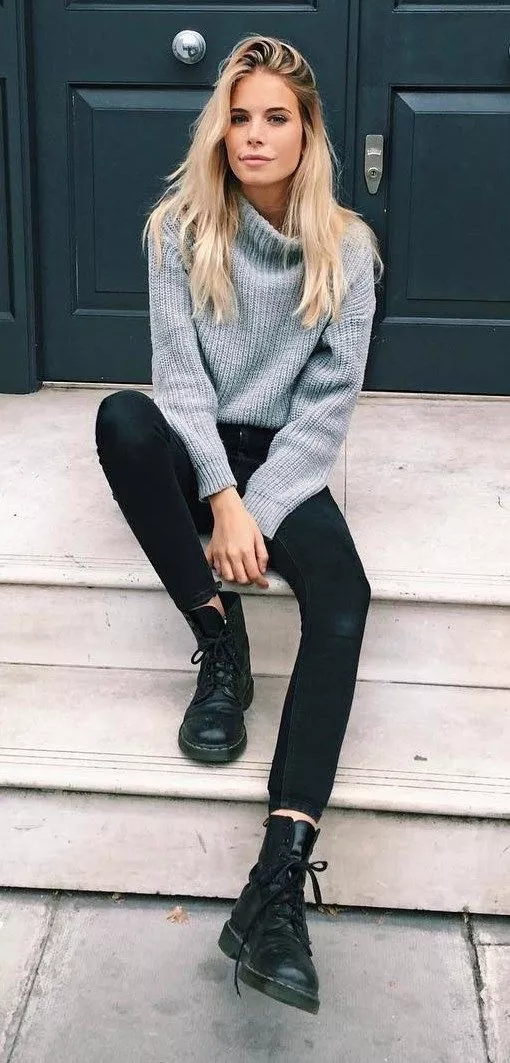 Девушка в сером свитере, черных джеггинсах и армейских ботинках