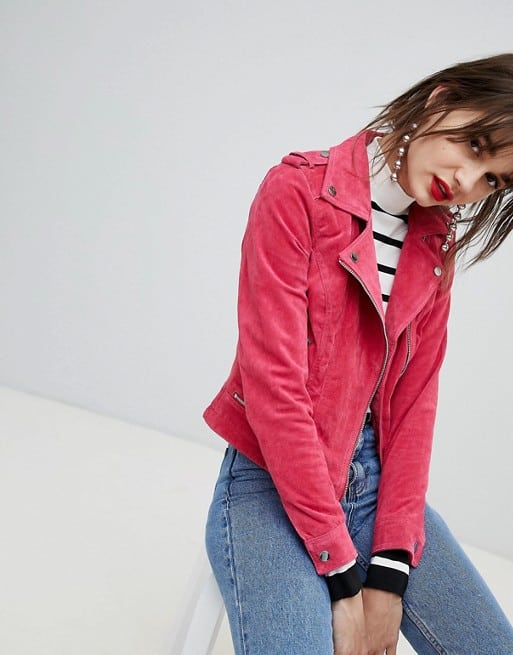 Девушка в джинсах и розовой укороченной куртке
