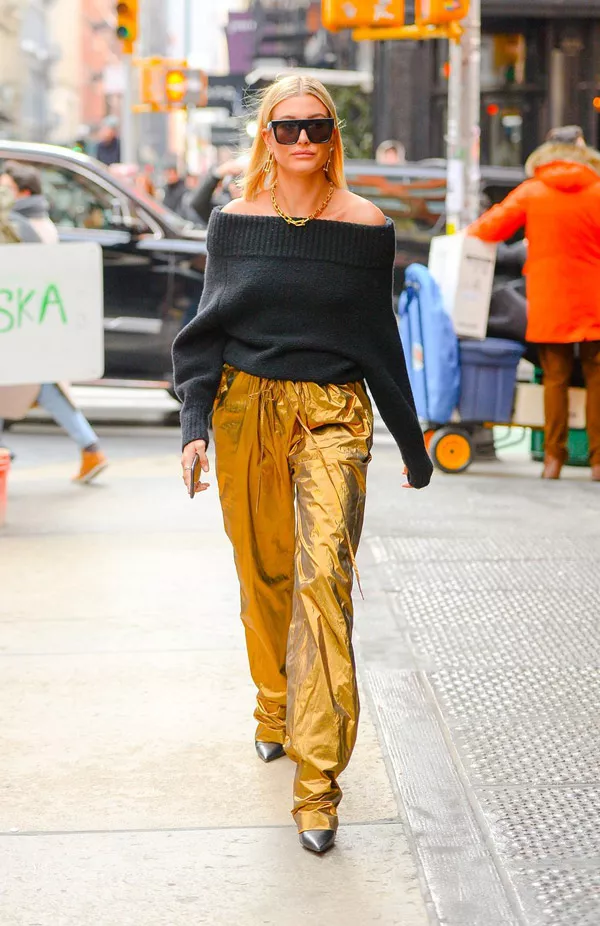Хейли Болдуин в золотых широких брюках и черном свитере