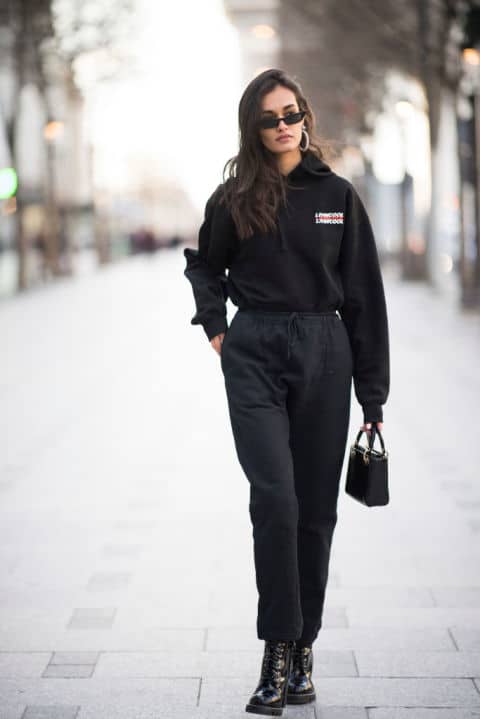 Девушка в черных штанах, толстовка и черные солнцезащитные очки
