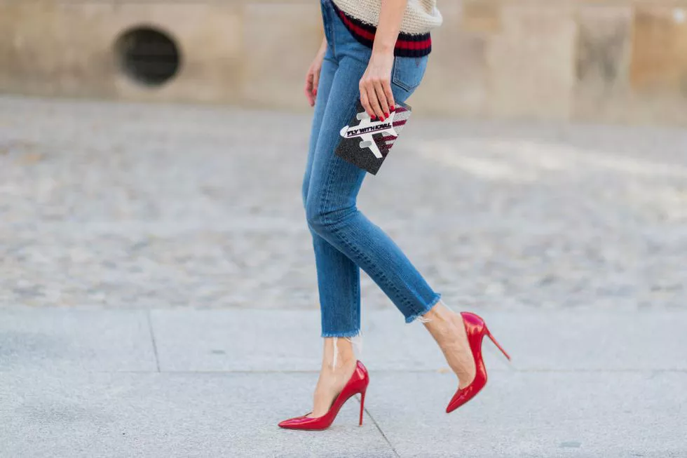 Девушка в красных туфлях, укороченные джинсы и маленькя сумочка