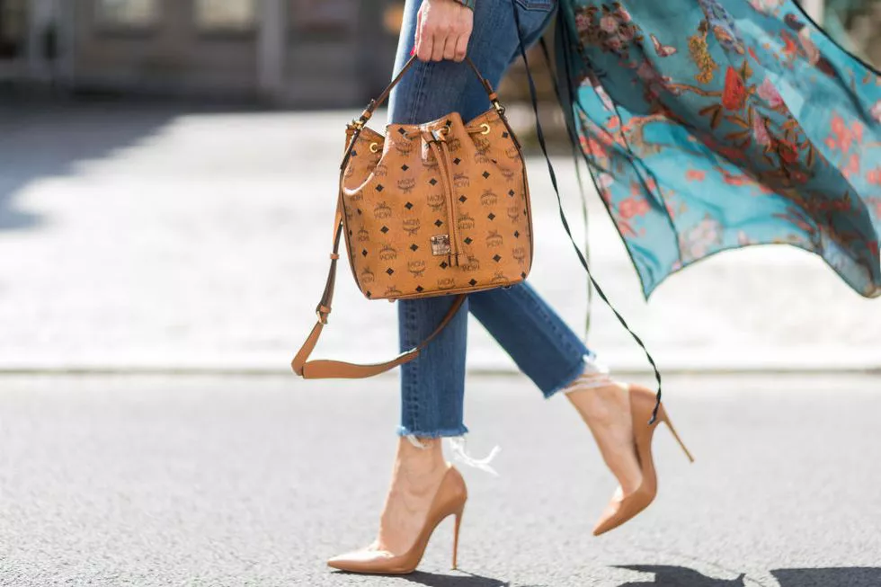 Девушка в укороченных джинсах, бежевые туфли на шпильке и сумка-мешок
