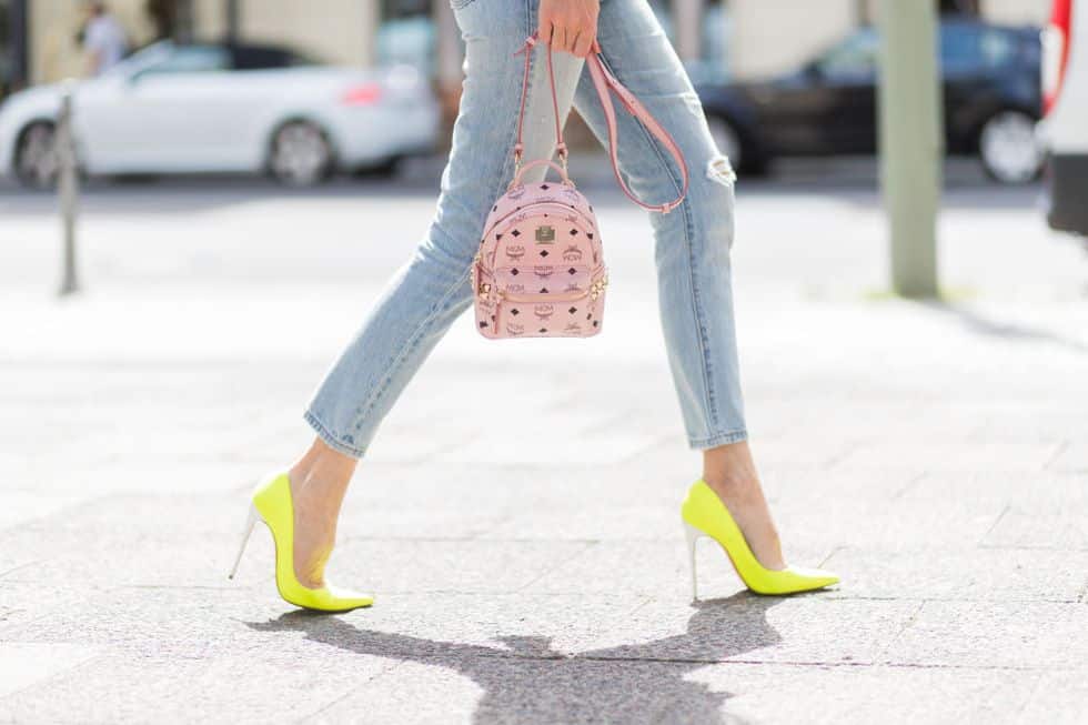 Девушка в желтых туфлях на шпильке и укороченные джинсы