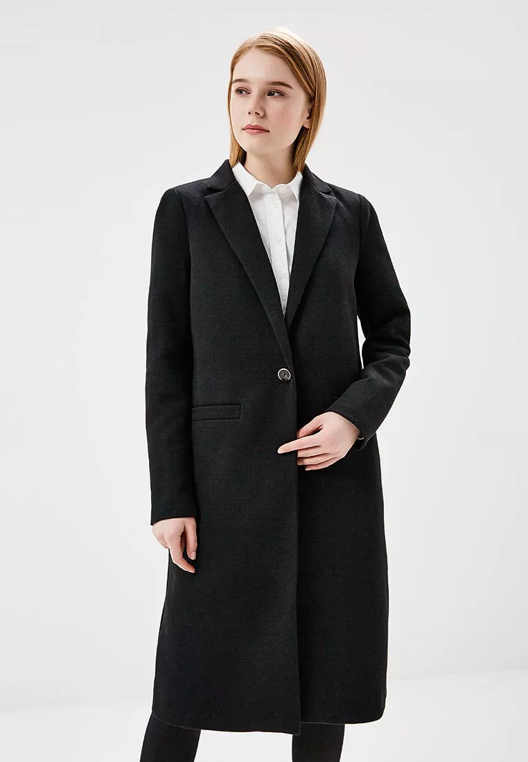 Модель в черном прямом пальто в мужском стиле