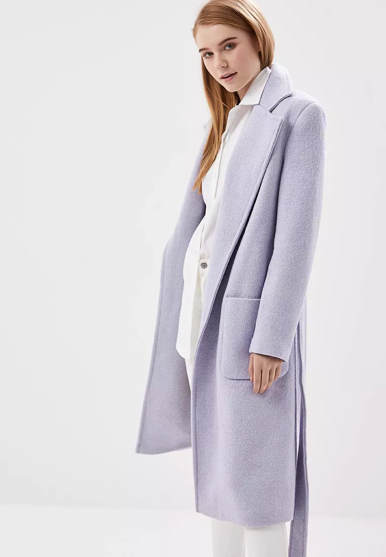Модель в пальто в пастельном оттенке с нкладными карманами