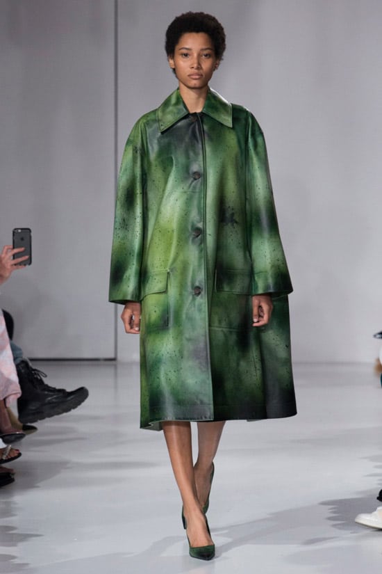 Модель в зеленом кожаном плаще оверсайз на модном показе Calvin Klein