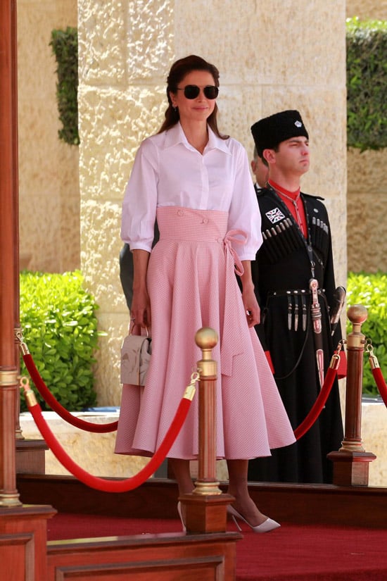 Королева Рания в юбке миди с корсетом, простая белая рубашка и светлые туфли и сумочка