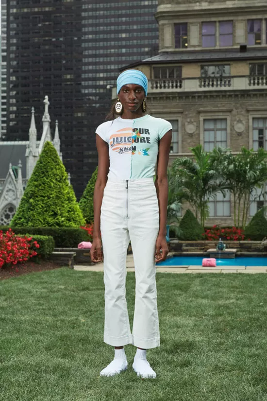 Модель в белых укороченных джинсах клеш и футболка с надписью от Juicy Couture