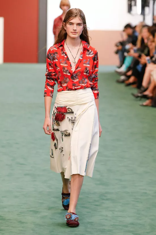 Модель в красной блузке с принтом и светлой юбке миди от Charm's
