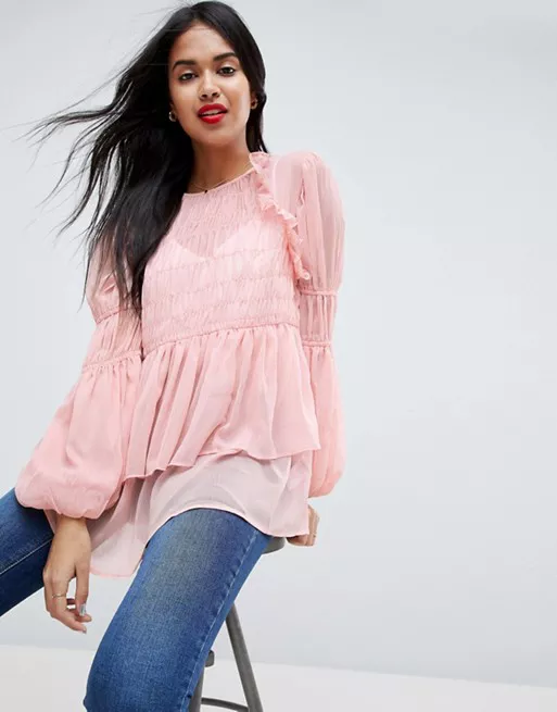 Модель в легкой розовой блузке с пышными рукавами