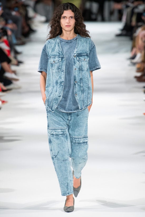 Модель в широких джинсах, синяя футболка и джинсовая жилетка от Stella McCartney