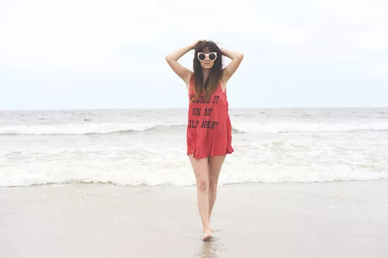 Девушка в красной удлиненной майке на пляже 
