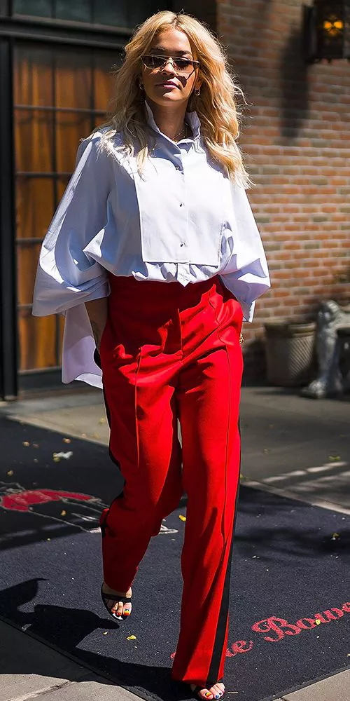 Рита Ора в красных брюках и красивой белой рубашке, крутой образ