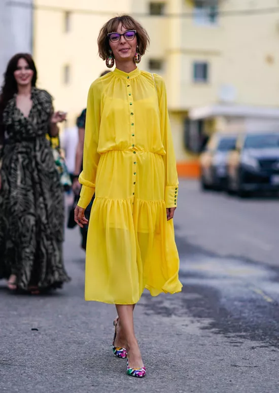 Модель в рком желтом платье миди и разноцветных туфлях