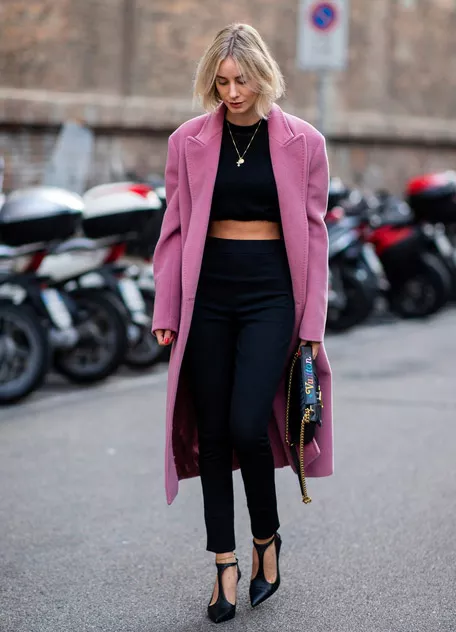 Девушка в розовом пальто, черных джинсах скинни и кроп топ