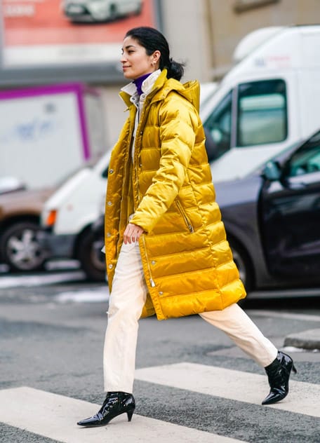 Девушка в желтом синтепоновом пальто и белых брюках