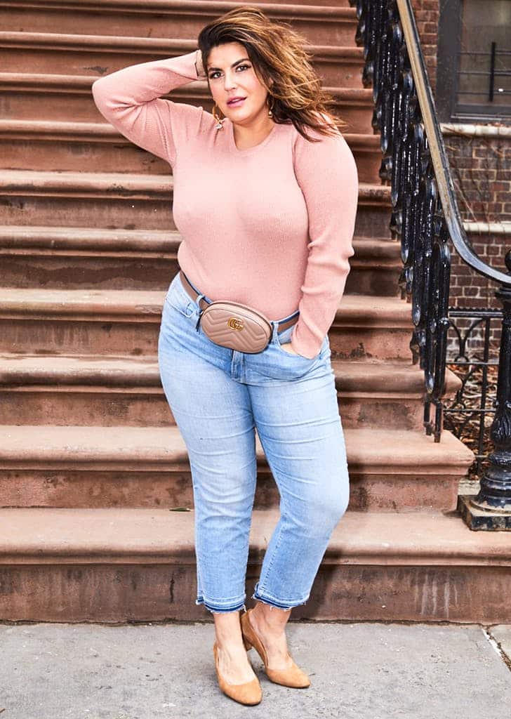 Katie Sturino в укороченных джинсах, розовый свитер и поясная сумка